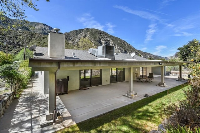 2447 Stonyvale Rd, Tujunga, CA 91042 - back of property featuring a mountain view, a chimney, a patio, and stucco siding