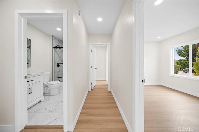 hall with recessed lighting, marble finish floor, and baseboards