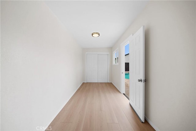 hallway with light wood finished floors and baseboards
