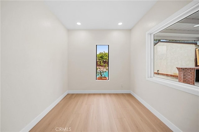 spare room with baseboards, recessed lighting, wood finished floors, and a fireplace