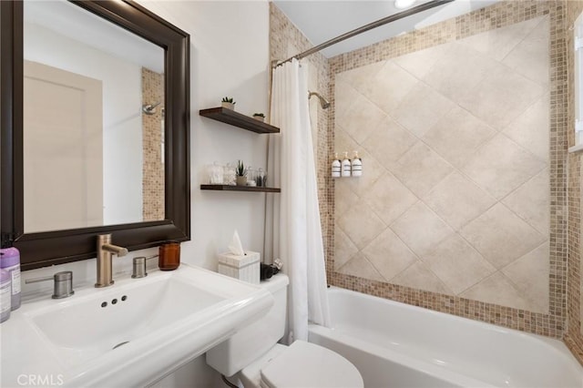 bathroom with toilet, a sink, and shower / bath combo with shower curtain