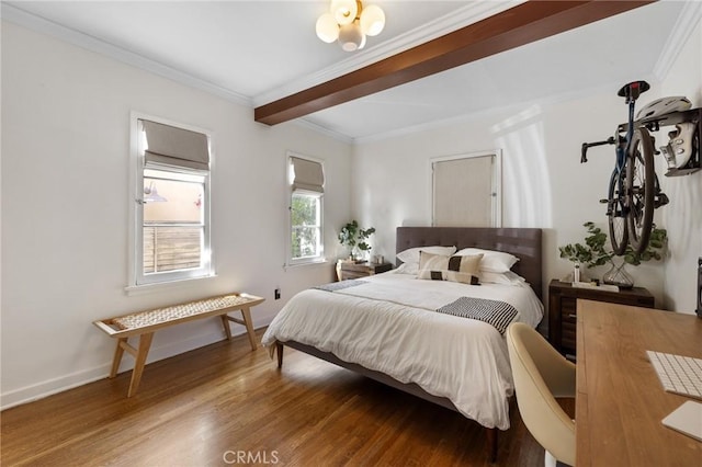 bedroom with baseboards, beamed ceiling, wood finished floors, and crown molding