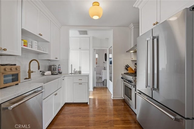 kitchen with high end appliances, visible vents, light countertops, and white cabinetry