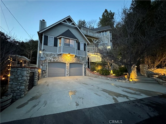 27596 N Bay Rd, Lake Arrowhead, CA 92352 - view of front of property featuring stone siding, an attached garage, a chimney, and concrete driveway