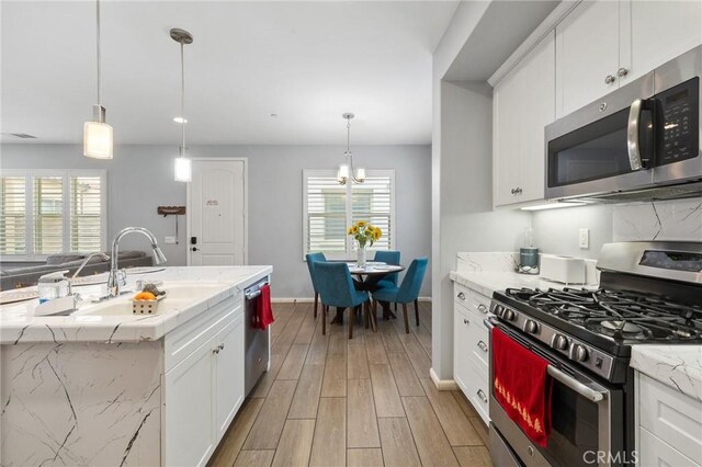 21730 Bene Dr, Saugus, CA 91350 - kitchen with a sink, light wood-type flooring, appliances with stainless steel finishes, and a wealth of natural light