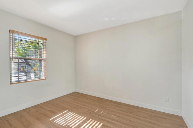 unfurnished room with light wood-style flooring and baseboards