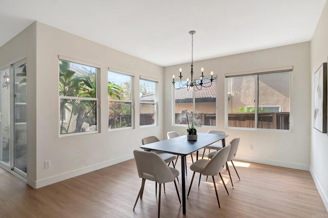 dining room featuring an inviting chandelier, light wood-style flooring, and baseboards