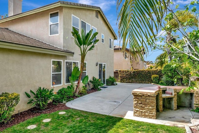 exterior space featuring a tiled roof, stucco siding, and a patio area
