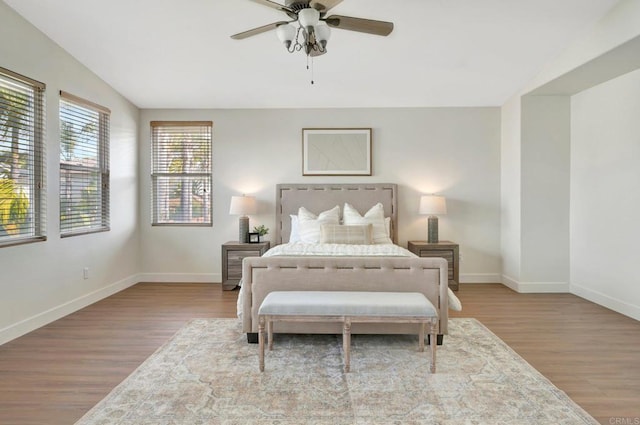 bedroom featuring baseboards, ceiling fan, wood finished floors, and vaulted ceiling