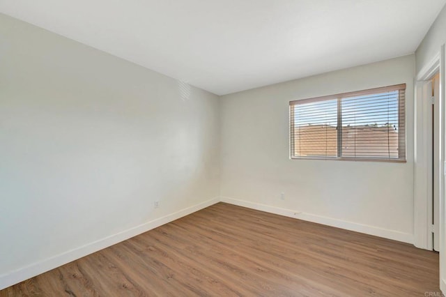 unfurnished room with baseboards and wood finished floors