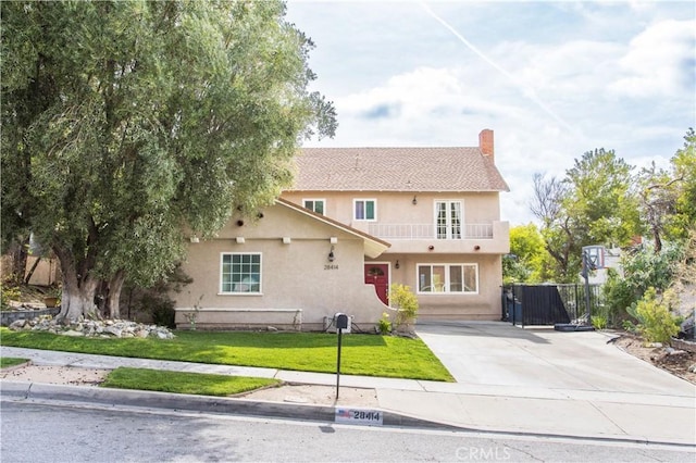 28414 Winterdale Dr, Canyon Country, CA 91387 - traditional-style house featuring concrete driveway, fence, a balcony, a front yard, and stucco siding