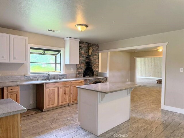 47409 Thunderhill Ln, Squaw Valley, CA 93675 - kitchen featuring light wood-style flooring, light stone counters, white cabinetry, and a kitchen breakfast bar