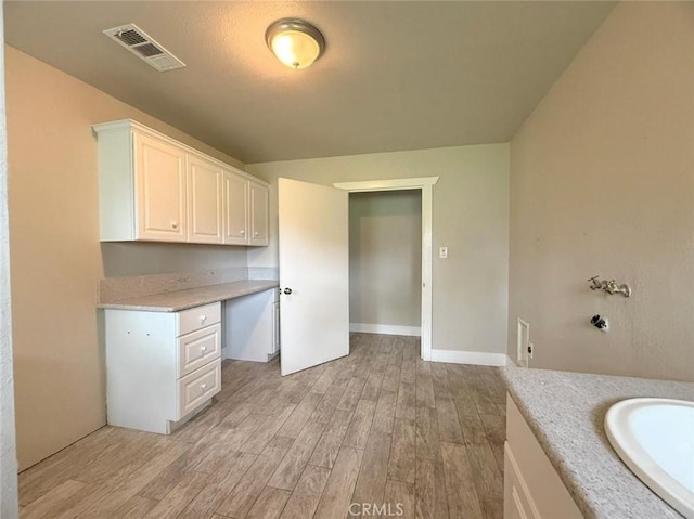 47409 Thunderhill Ln, Squaw Valley, CA 93675 - kitchen with built in desk, light wood-style floors, light countertops, and white cabinets