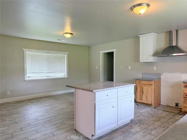 47409 Thunderhill Ln, Squaw Valley, CA 93675 - kitchen with wall chimney exhaust hood, light wood-type flooring, white cabinetry, light stone counters, and a kitchen island