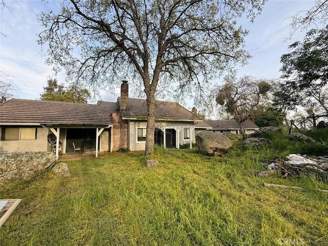 47409 Thunderhill Ln, Squaw Valley, CA 93675 - rear view of property featuring a chimney, stucco siding, and a tiled roof