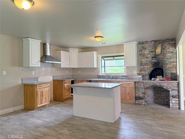 47409 Thunderhill Ln, Squaw Valley, CA 93675 - kitchen featuring wall chimney exhaust hood, light wood-style flooring, a center island, and white cabinets