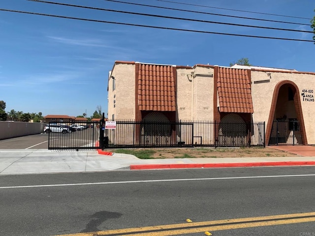 438 S Anza St, El Cajon, CA 92020 - view of front of house with uncovered parking, fence, stucco siding, and a tile roof