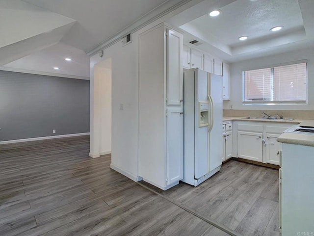 438 S Anza St, El Cajon, CA 92020 - kitchen featuring light wood-style flooring, white fridge with ice dispenser, a tray ceiling, and visible vents