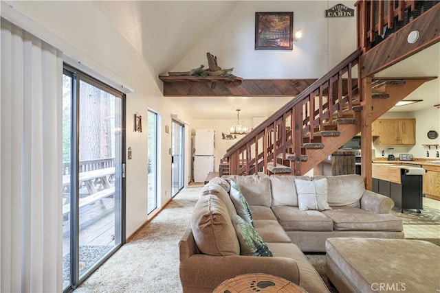 living room with a chandelier, light carpet, high vaulted ceiling, and stairs