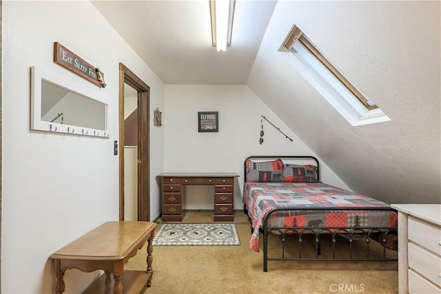 bedroom featuring lofted ceiling with skylight and carpet flooring