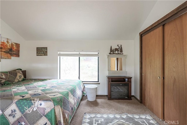 bedroom featuring a closet, light carpet, and lofted ceiling