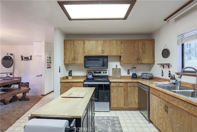 kitchen with stainless steel appliances, stacked washing maching and dryer, wooden counters, a sink, and light floors