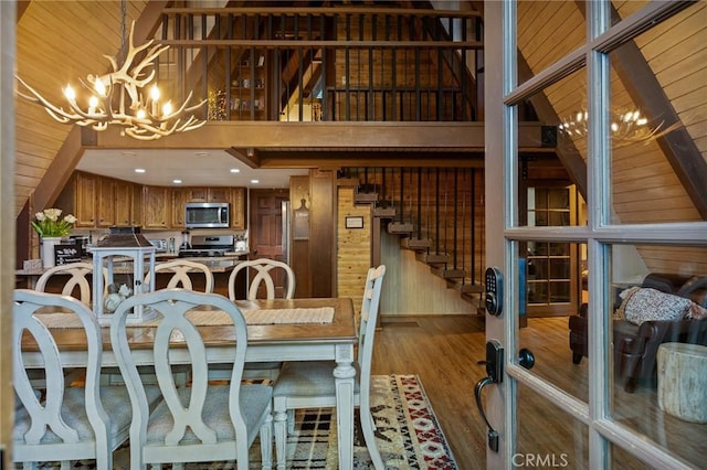 31353 Lightfoot Way, Running Springs, CA 92382 - dining room with a chandelier, wood finished floors, wooden walls, and a towering ceiling