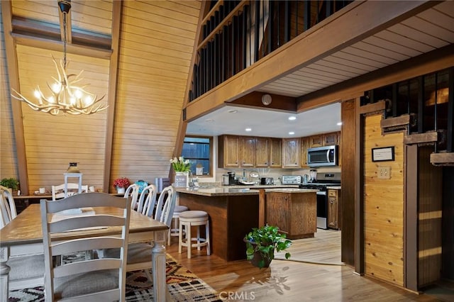 31353 Lightfoot Way, Running Springs, CA 92382 - dining area featuring a chandelier, wood walls, light wood finished floors, and recessed lighting