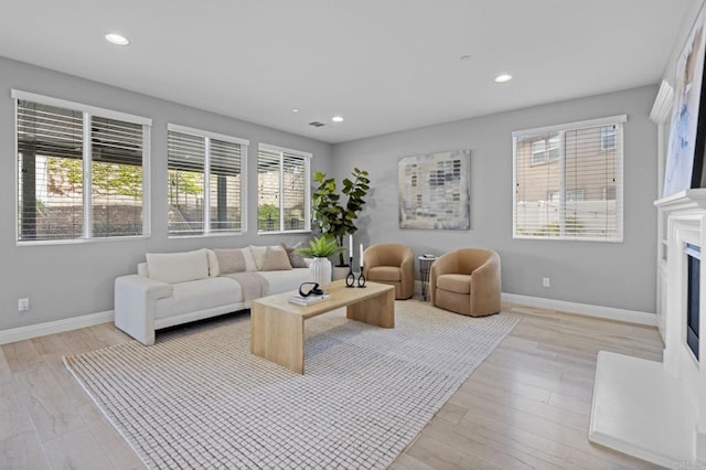 living area featuring baseboards, plenty of natural light, and recessed lighting