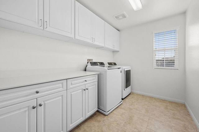 clothes washing area featuring cabinet space, baseboards, and independent washer and dryer