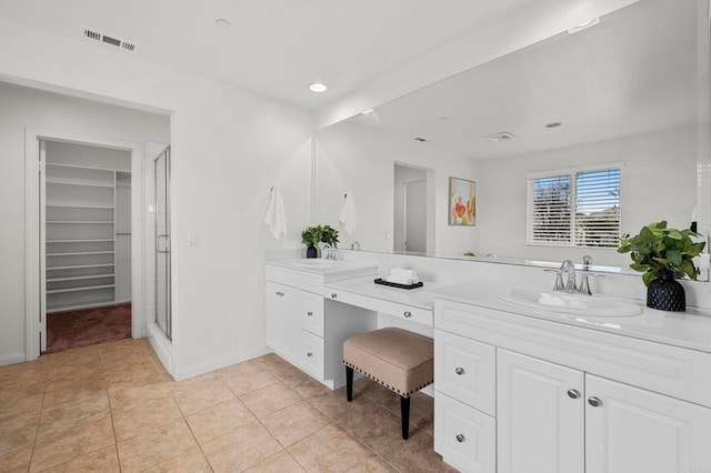 bathroom with a stall shower, vanity, baseboards, and visible vents