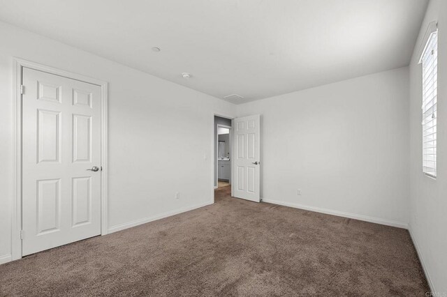 unfurnished bedroom with baseboards and carpet floors