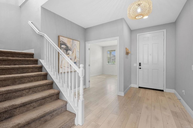 entryway featuring stairway, baseboards, and light wood-style floors
