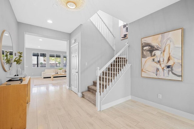 stairs with wood finished floors, baseboards, and recessed lighting