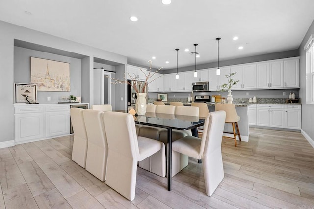 dining room with light wood-style floors, baseboards, and recessed lighting