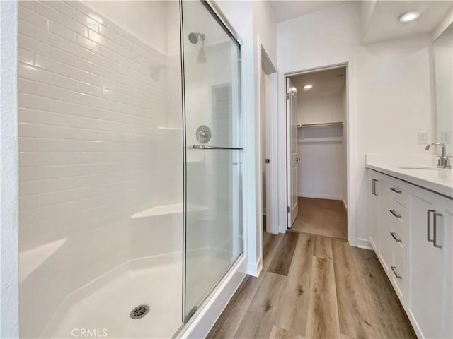 11032 Momentum Dr, Rancho Cucamonga, CA 91730 - bathroom featuring a shower stall, vanity, a spacious closet, recessed lighting, and wood finished floors