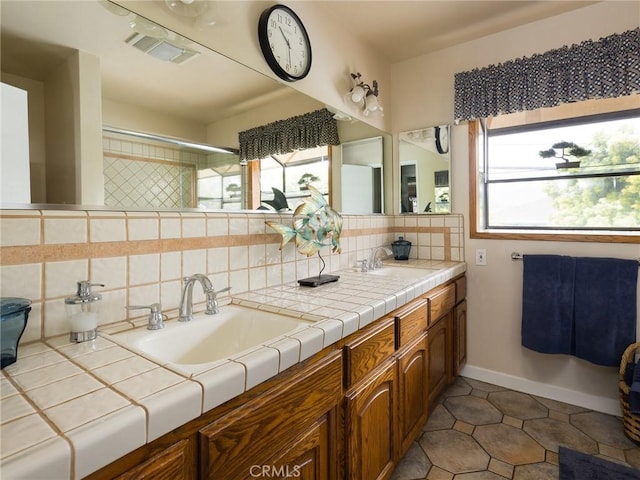full bathroom with plenty of natural light, visible vents, and a sink
