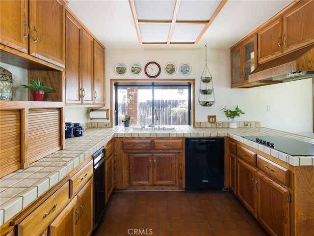 kitchen featuring a sink, black appliances, and brown cabinets