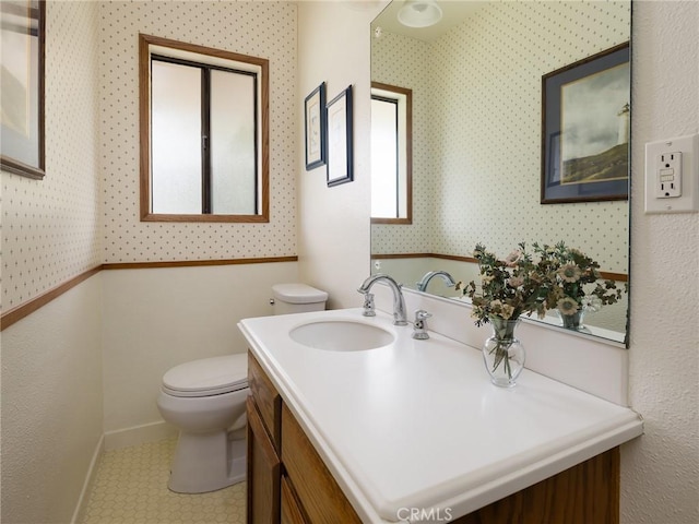 bathroom featuring baseboards, toilet, and vanity