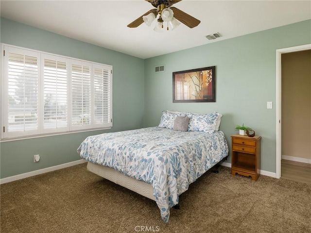 carpeted bedroom with baseboards, ceiling fan, and visible vents