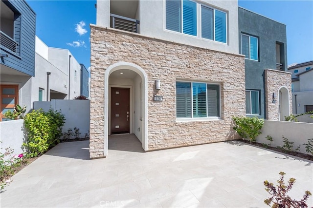 contemporary house featuring stone siding and stucco siding