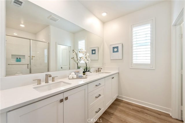 bathroom with a sink, visible vents, baseboards, and a stall shower