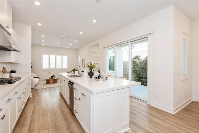 kitchen with visible vents, a sink, light wood-style floors, white cabinetry, and stainless steel appliances