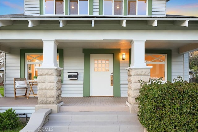 exterior entry at dusk featuring covered porch