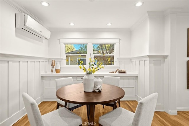 dining room with a decorative wall, a wainscoted wall, and a wall unit AC