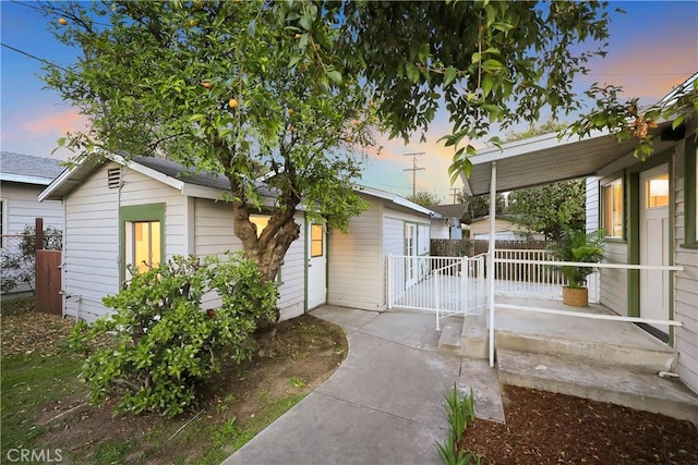 property exterior at dusk featuring fence