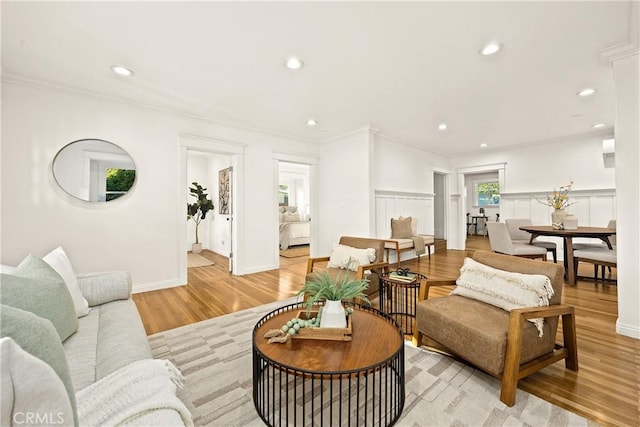 living room featuring recessed lighting, crown molding, and light wood finished floors