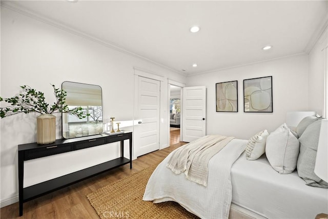 bedroom featuring ornamental molding, wood finished floors, and recessed lighting