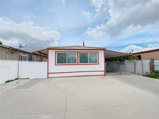 exterior space featuring fence, a gate, driveway, and a carport