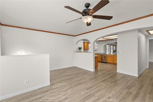 unfurnished living room with arched walkways, baseboards, light wood-type flooring, and a ceiling fan